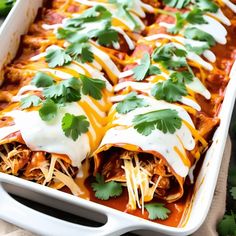 a white casserole dish filled with chicken enchiladas