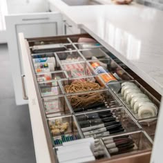 an organized drawer in a kitchen filled with pens, pencils and other office supplies