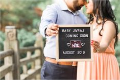 a man and woman holding up a sign that says baby juraj coming soon august 2019