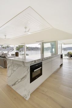 a kitchen with marble counter tops and an oven in the center, along with hardwood floors