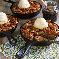 three skillets filled with pecans, ice cream and caramel on a table