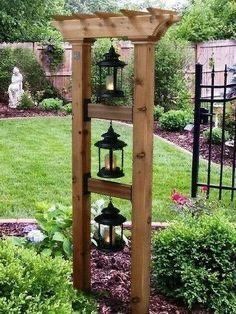 a wooden structure with lanterns hanging from it's sides in the middle of a garden