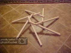 a group of wooden sticks arranged in the shape of a star on a tile floor