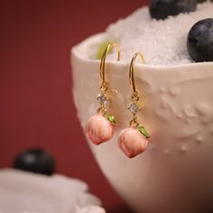 Experience the magic of nature with our Peach Earrings. Featuring a delicate enameled peach adorned with sparkling cubic zirconia, these lovely earrings add a touch of glamour to any style. You'll enjoy the sweetness and cheer of summer they bring to you. Embrace your love for fruit jewelry with these stunning earrings! DETAILS Plating: 18K Gold Materials: 18K Gold on Brass, Enamel, Cubic Zirconia Size: 1.34 "*0.39"(3.4c m*1cm) Weight: 8.3g Fruit Necklace, Everyday Wear Jewelry, Peach Earrings, Astrology Jewelry, Astrology Necklace, Moon And Star Ring, Moon And Star Earrings, Fruit Jewelry, Zodiac Bracelet