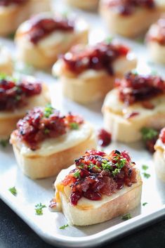 small appetizers with cranberry sauce and parsley on top are ready to be eaten