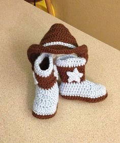 a crocheted cowboy hat and booties sitting on top of a countertop