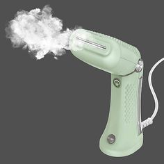 a green blow dryer with white steam coming out of it's back end