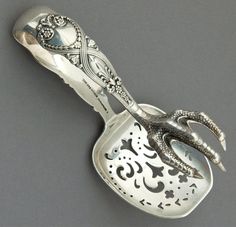 an ornately decorated spoon is shown on a gray surface with black and white designs