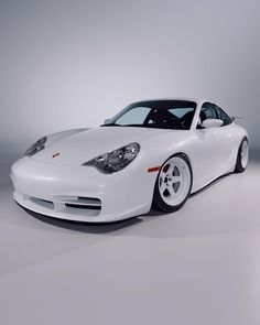 a white sports car parked in a studio