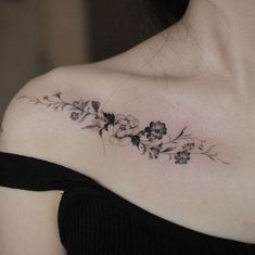 a woman's shoulder with flowers on it and the word love written in black ink