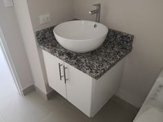 a white sink sitting on top of a counter next to a toilet