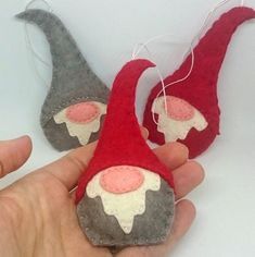 someone is holding two felt ornaments in their hands