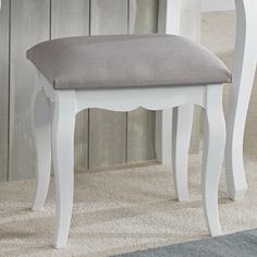 a white bench with a gray cushion on it