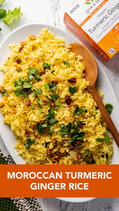 moroccan turmeric ginger rice on a white plate with a wooden spoon next to it