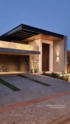 a house with a bike parked in front of it and lights on the side of the building