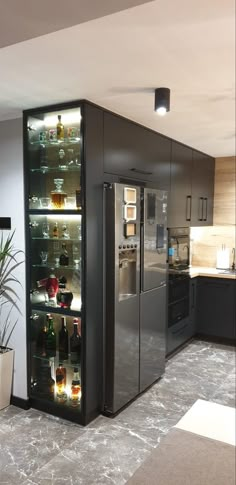 a refrigerator freezer sitting inside of a kitchen next to a potted plant