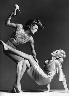 an old photo of two people in dance pose with one holding the other's leg