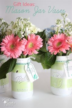 two mason jars with pink and white flowers in them