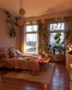 a cat sitting on top of a bed next to a window in a room with wooden floors