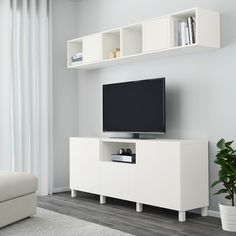 a white entertainment center with shelves and a flat screen tv on it's side