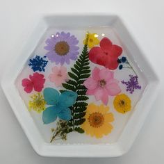 a white plate with flowers and plants in it