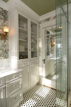 a bathroom with white cabinets and black and white checkered floor