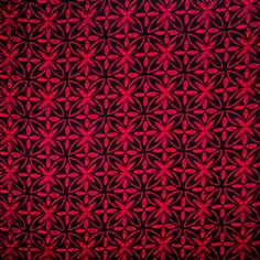 a red and black wallpaper with an intricate design on it's surface,