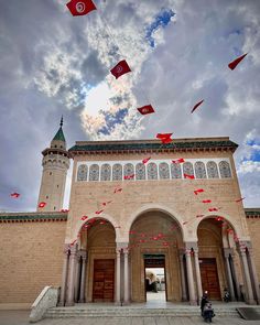 kites flying in the sky above a building