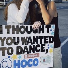 two women standing next to each other holding a sign that says thought you wanted to dance