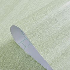 a close up view of a light green fabric with a white knife sticking out of it