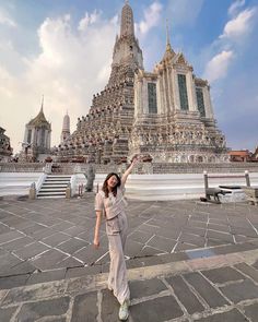 a woman standing in front of a very tall building