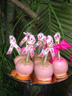 pink and gold decorated desserts are on a tray in front of some palm trees