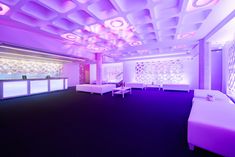 a room with purple lighting and white furniture