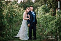 a bride and groom standing in the middle of a vineyard at their wedding day, posing for a photo