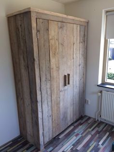 a wooden cabinet sitting in the corner of a room next to a radiator