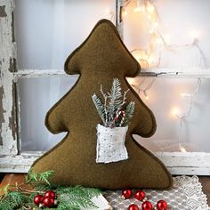 a felt christmas tree decoration sitting on top of a wooden table next to a window