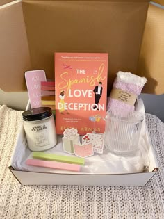 the spanish love deception box is packed with books, candles, and other decorative items