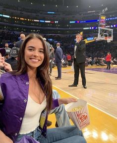 a woman sitting on top of a basketball court