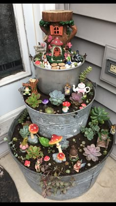 three tiered metal planter with plants and gnome figurines