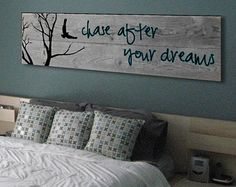 a bed sitting under a wooden sign on the wall