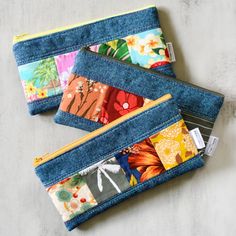 three zippered pouchs with different designs on them sitting next to eachother