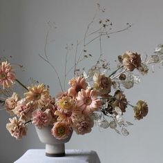 an arrangement of flowers in a vase on a table