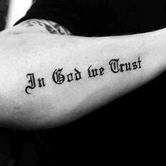 a man with a tattoo on his arm that says in god we trust