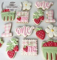 some decorated cookies are sitting on a white table and one is pink, the other is green