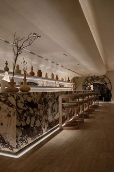 a bar with marble counter tops and stools in a room that has wooden floors