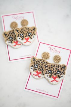 Our Azaline earring is a chic eye-catching cheetah. This style features metallic gold, black, red, and white beads & is designed by Mimi & her sister in Charleston, SC. Each earring is lightweight, hypoallergenic, and measures 2.25" x 2". Pineapple Earrings, Rainbow Beads, Beaded Clutch, Gifts For Teachers, Seed Bead Earrings, Beaded Tassels, Canvas Pouch, Art Deco Design, Earrings Collection