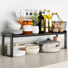 a shelf filled with pots and pans on top of a counter next to other kitchen utensils