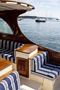 the inside of a boat with blue and white striped cushions on it's seats