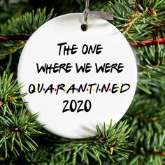 a white ornament hanging from a christmas tree with the words, the one where we were quarannated 2020