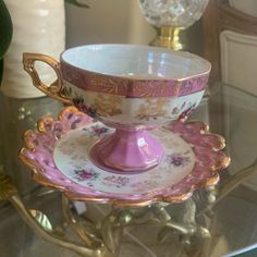 two cups and saucers sitting on top of a glass table